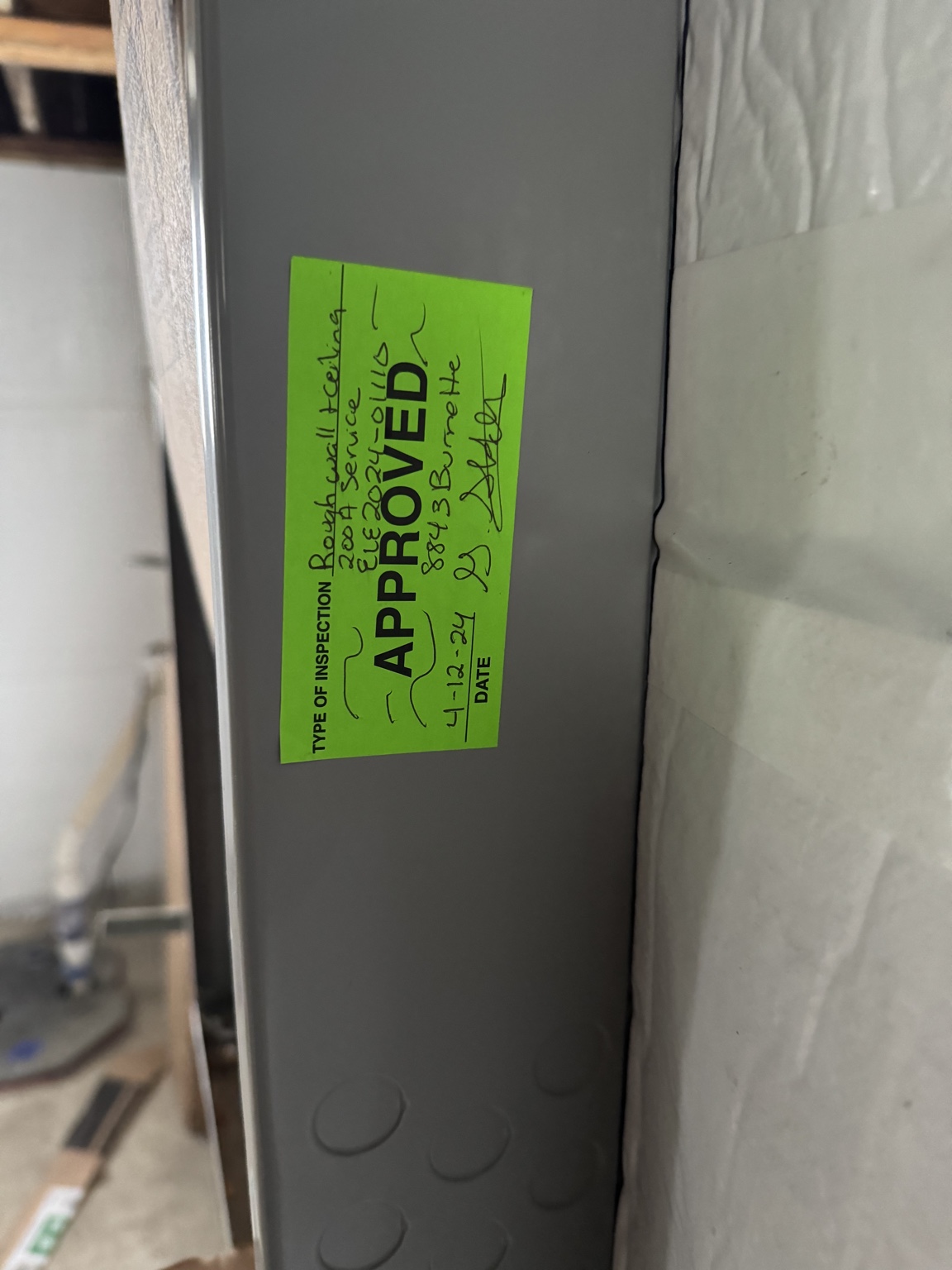 Green approved electrical inspection sticker on panel